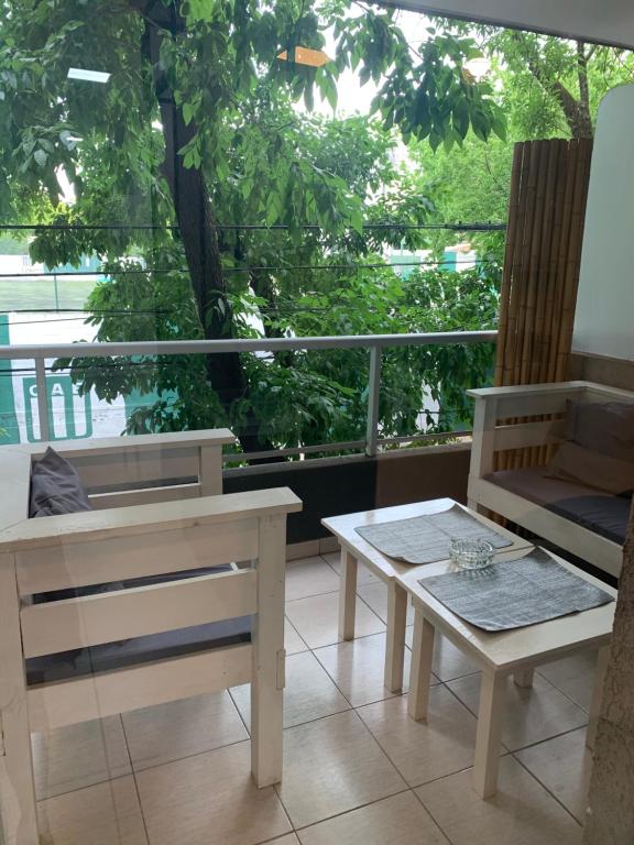 ブエノスアイレスにあるBelgrano Chic apartamentのテーブル、ベンチ、窓が備わる客室です。