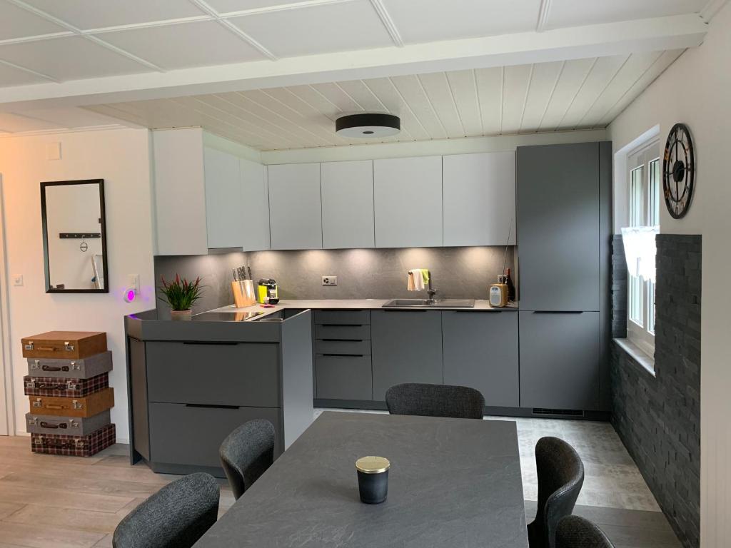 a kitchen with white cabinets and a table and chairs at La Maisonnette in Travers
