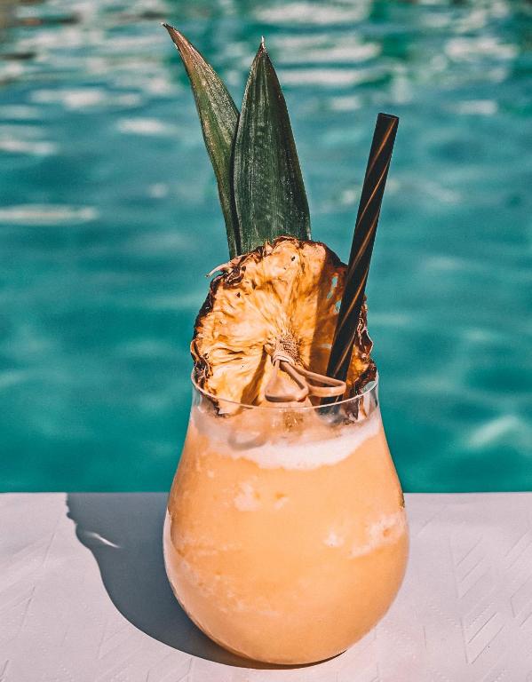a drink sitting on a table next to a pool at Branco Mykonos in Platis Gialos