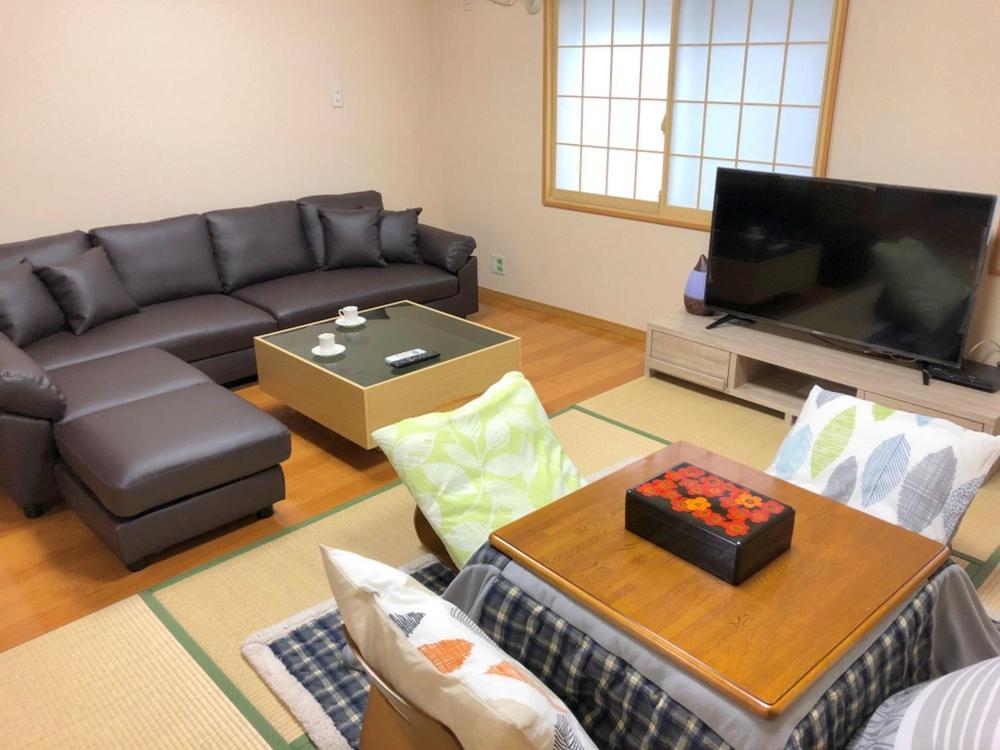 ein Wohnzimmer mit einem Sofa und einem Flachbild-TV in der Unterkunft 大阪西九条stay in Osaka