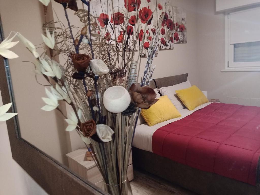 Un dormitorio con una cama con un jarrón de flores en Appartamento "Il Vicolo" en Peschiera del Garda