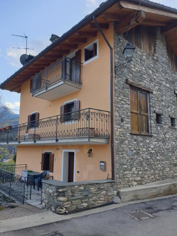 Una casa de piedra con balcón y mesa. en Casa MAEL - CIR 0017, en Saint-Pierre