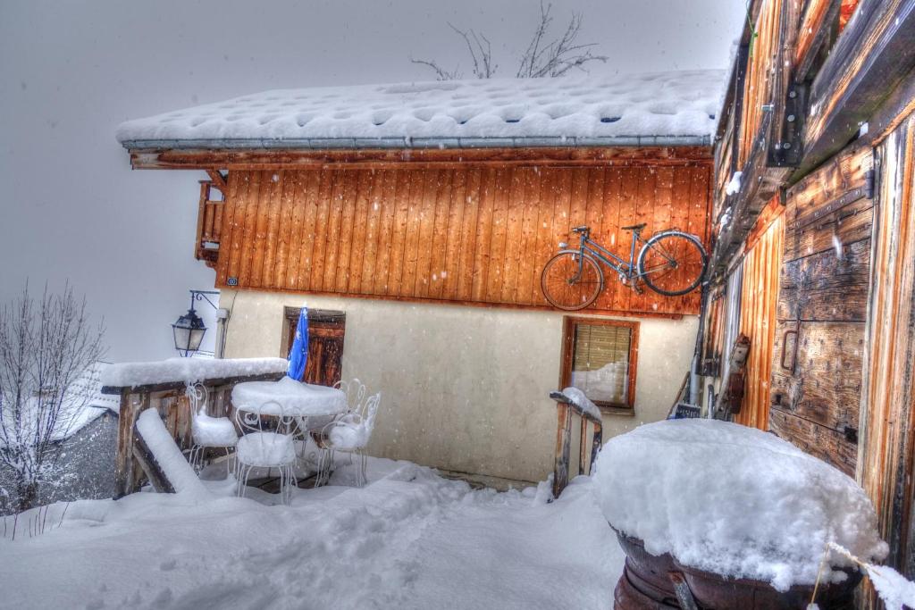 uma casa com uma bicicleta no telhado na neve em petite maison à Huez em LʼHuez