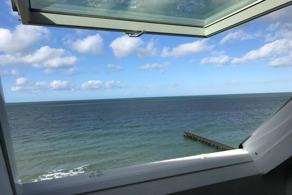 a view of the ocean from a window at Appartement front mer proche omaha & utah beach - 3 in Grandcamp-Maisy