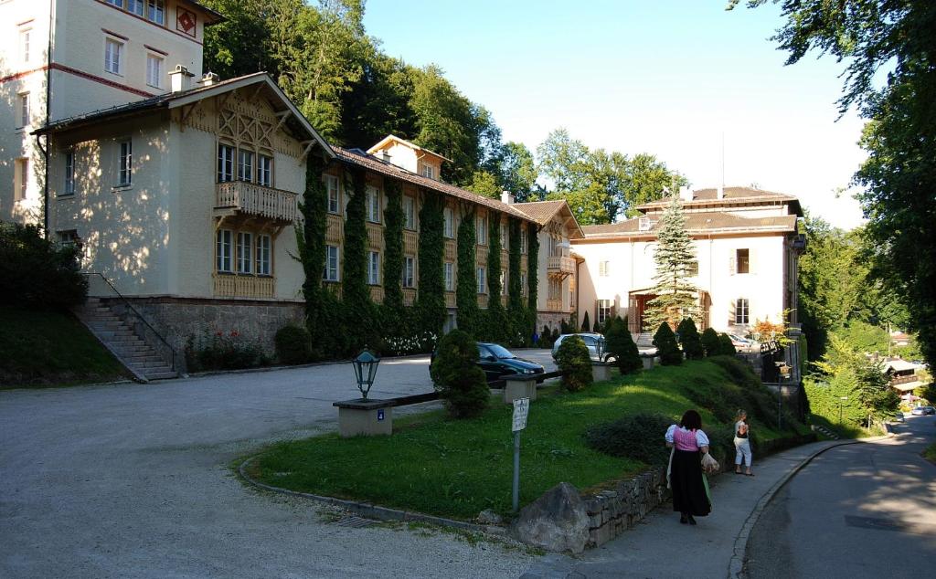 two people standing in front of a large building at Ferienappartement Königliche Villa Berchtesgaden in Berchtesgaden
