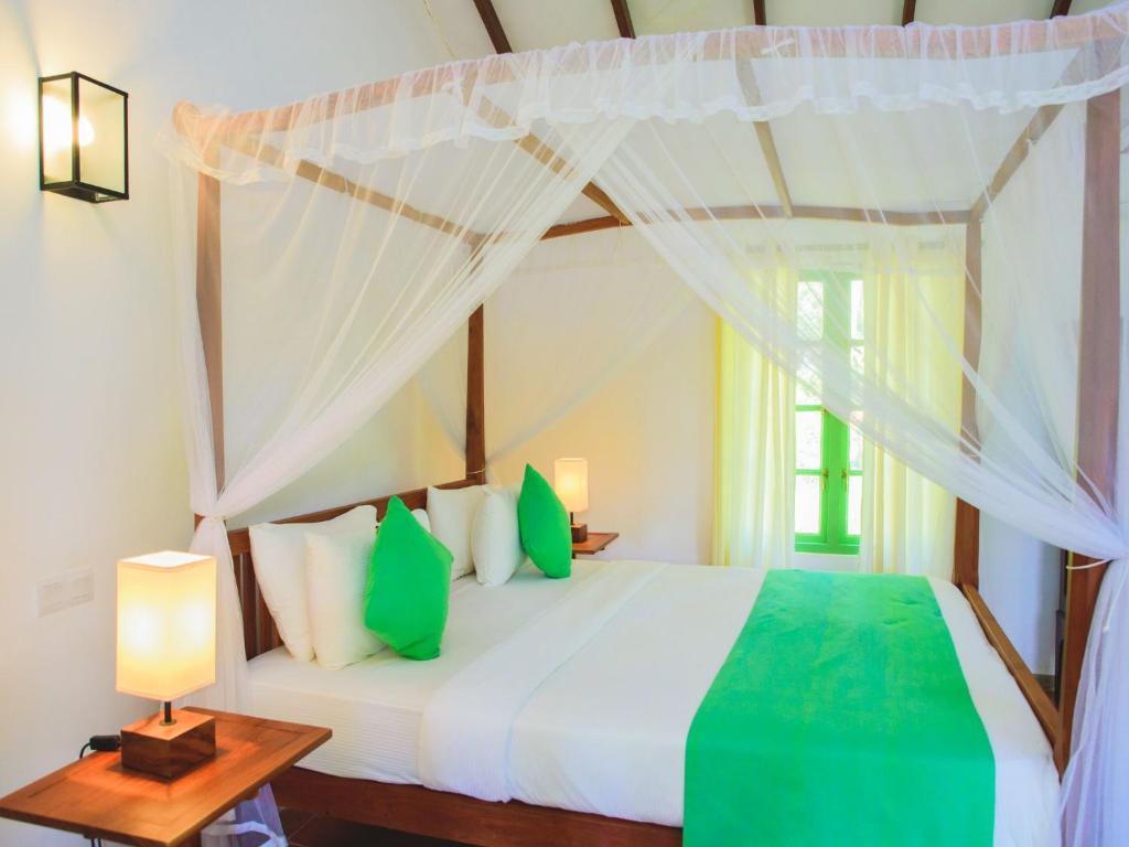 a bedroom with a bed with a canopy at Thalpe Walawwa Heritage Villa With Private Beach Access in Unawatuna