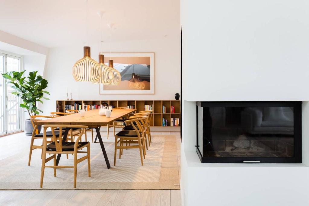 a dining room with a table and chairs and a tv at Dinesen Collection Luxury Condos in Copenhagen