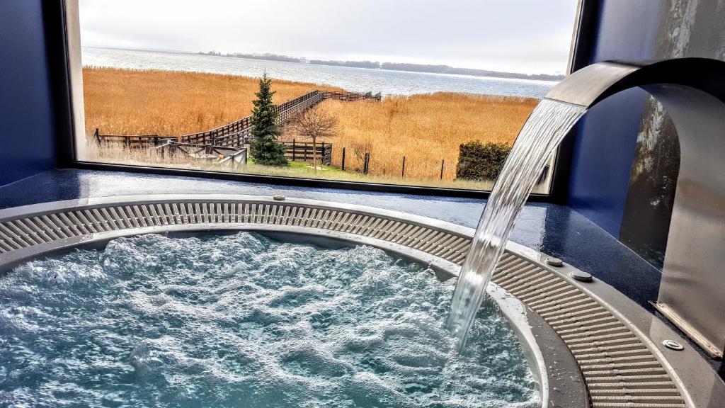 a bath tub with water coming out of a window at Avila Park & SPA in Dziwnówek