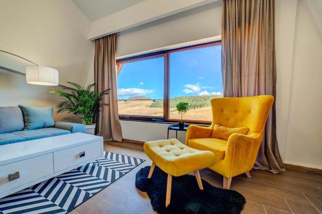 a living room with a yellow chair and a window at Zlatibor Hills Stars in Zlatibor