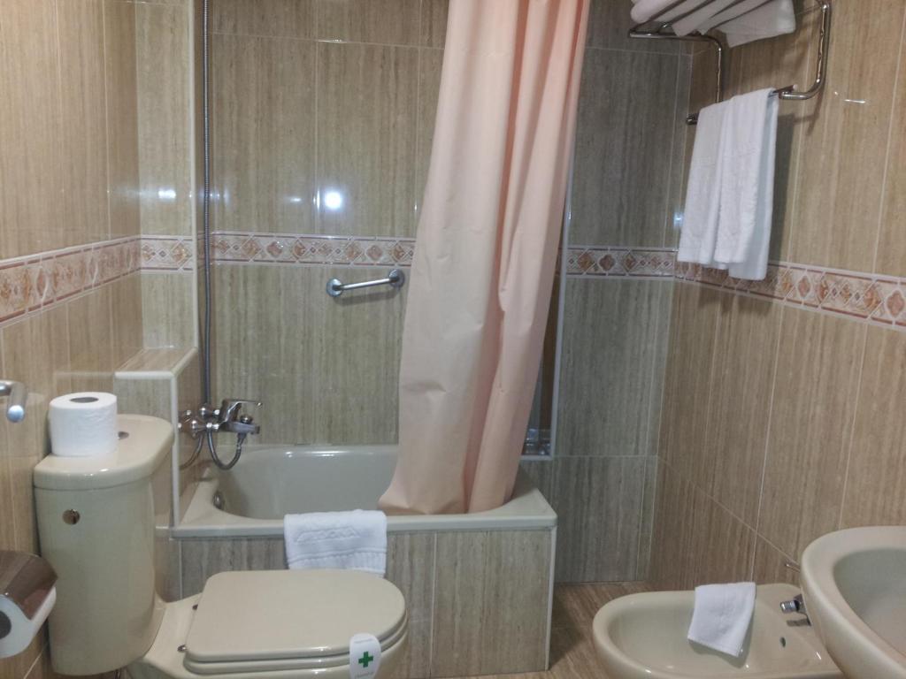 a bathroom with a toilet and a sink and a shower at Begoña Playa in Gijón