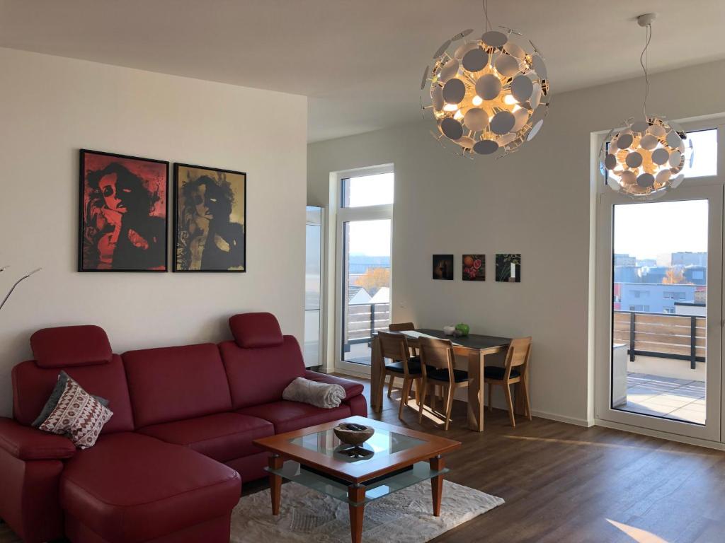 a living room with a red couch and a table at A&N Prestige Apartments "Attika" close to BASEL and Rhine river in Grenzach-Wyhlen