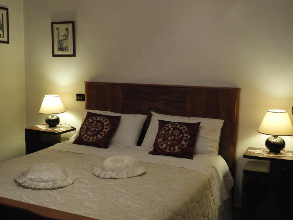 una camera da letto con un letto con cuscini e due lampade di Il Falco Grillaio a Laterza