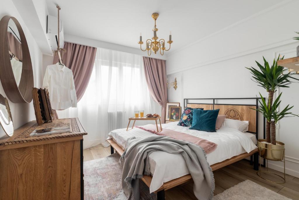 um quarto com uma cama grande e um lustre em Eclectic 3 bedroom Calea Victoriei em Bucareste