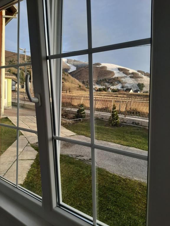 Una ventana con vista a una montaña cubierta de nieve. en -Moon-, en Kupres