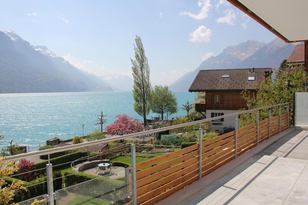 a house with a balcony with a view of the water at Beaulac Penthouse in Brienz