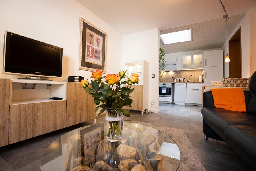 una sala de estar con un jarrón de flores sobre una mesa de cristal en Villa Duck-Dich-Südheide, en Hermannsburg