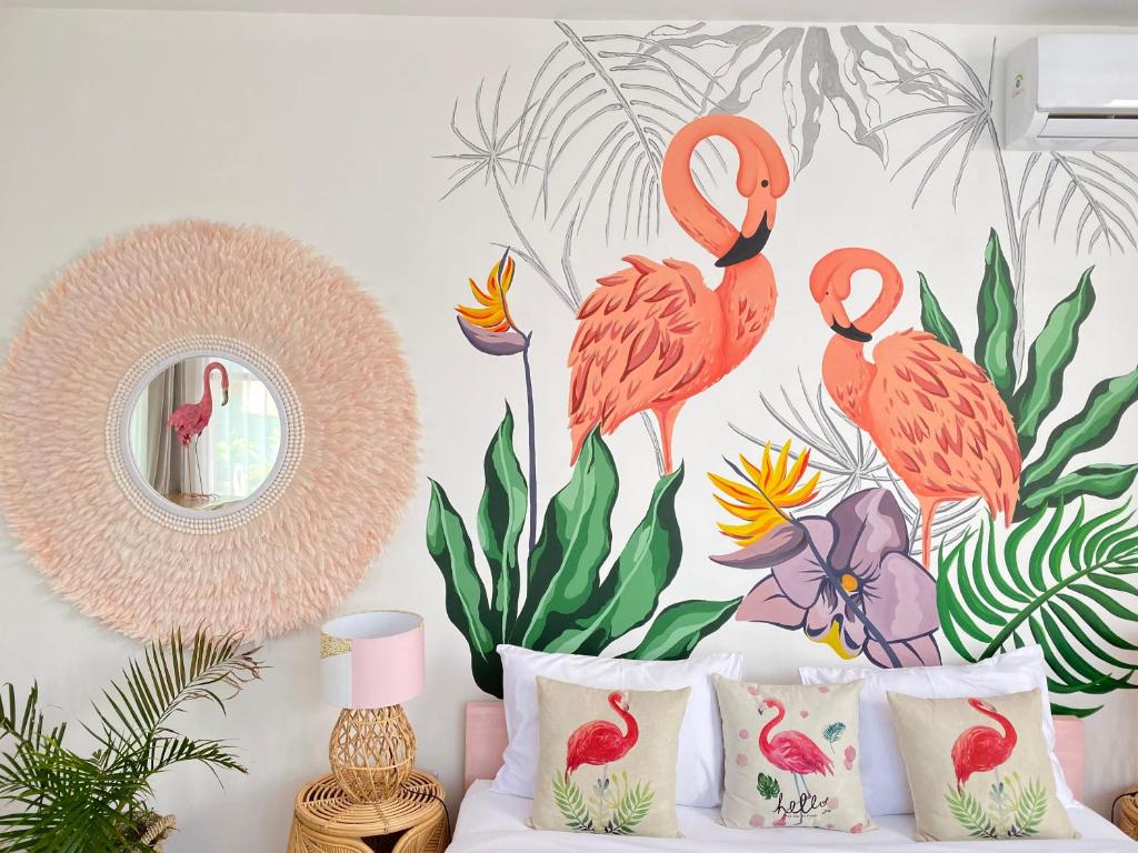 a bedroom with a flamingos mural on the wall at Flamingo in Gili Trawangan
