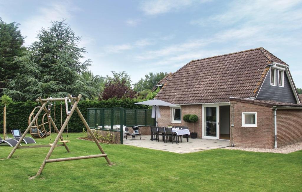 a yard with a playground and a house at Vakantiewoning aan het Veerse meer in Wolphaartsdijk