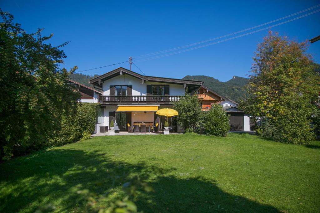 una casa grande con césped delante en Ferienwohnungen Schnabel im Herzen von Rottach-Egern, en Rottach-Egern