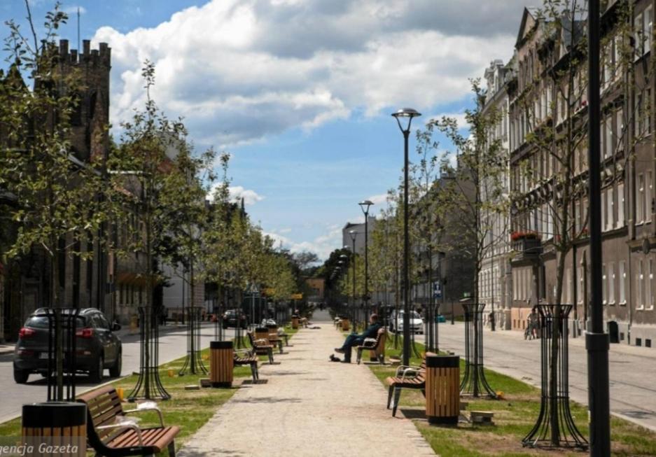a row of benches on a city street with buildings at Gdańsk in Gdańsk