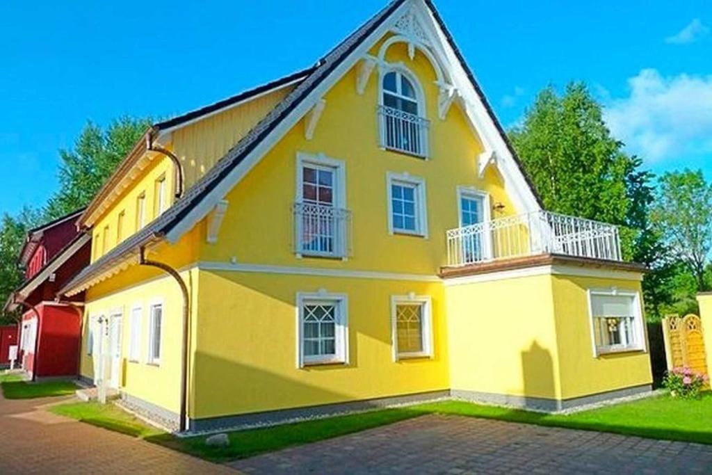 ein gelbes Haus mit weißen Fenstern auf einer Straße in der Unterkunft Quartier4u - 4 Sterne - inklusive POWER WLAN - BikeBox - Wäschepaket - Parkplatz # Bestpreisgarantie # in Zingst