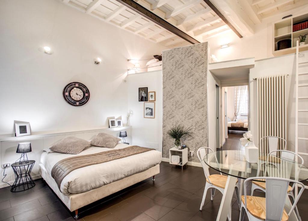 1 dormitorio con cama y mesa de cristal en Trastevere Miracle Suite, en Roma