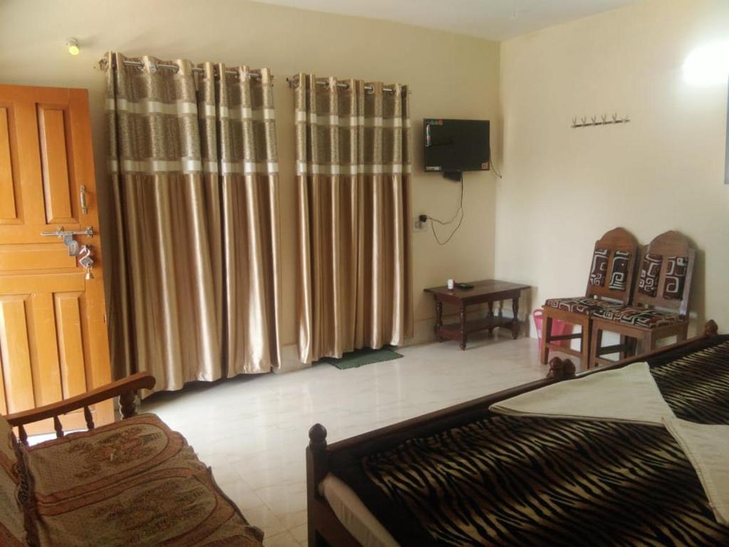 sala de estar con cortinas, sofá y TV en Van Vihar Resort, en Dhanwār
