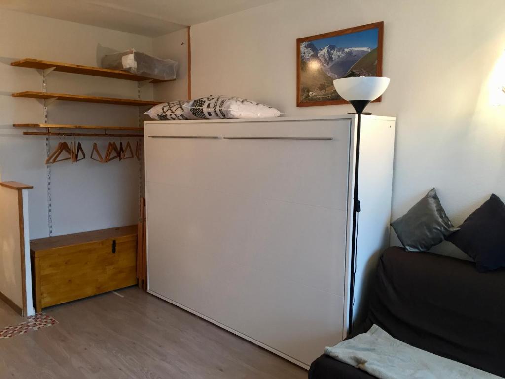 a large white refrigerator in a room with a couch at Studio pied des pistes in Villard-de-Lans