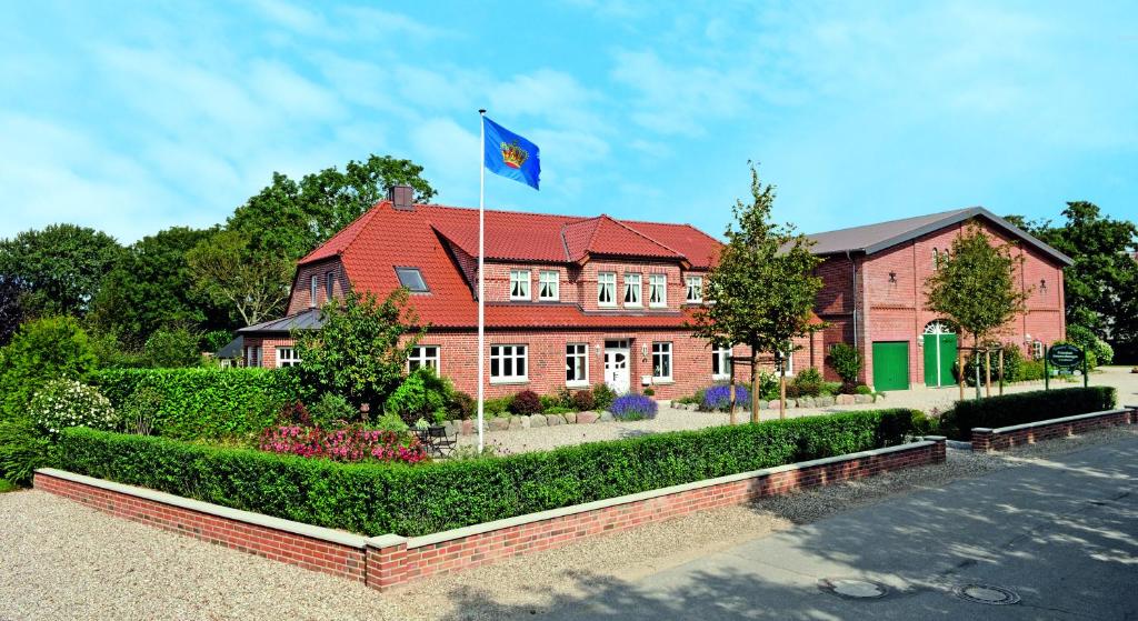 een huis met een blauwe vlag ervoor bij Ferienhof Kähler in Fehmarn