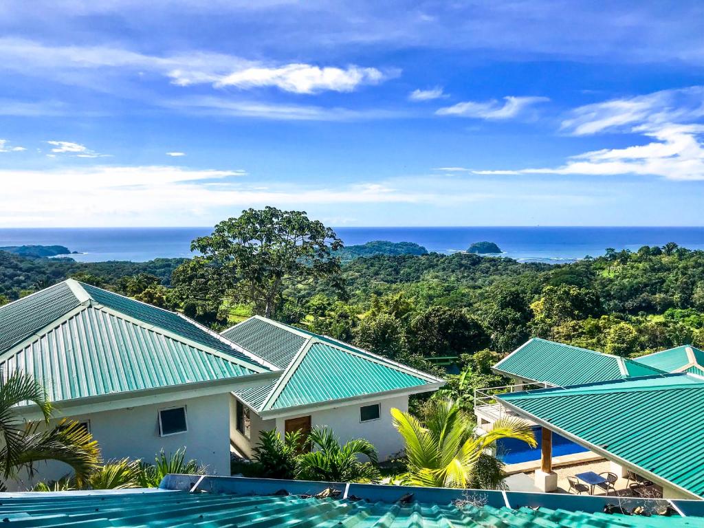 a view of a resort with green roofs and the ocean at Lodge Las Estrellas de Samara in Sámara