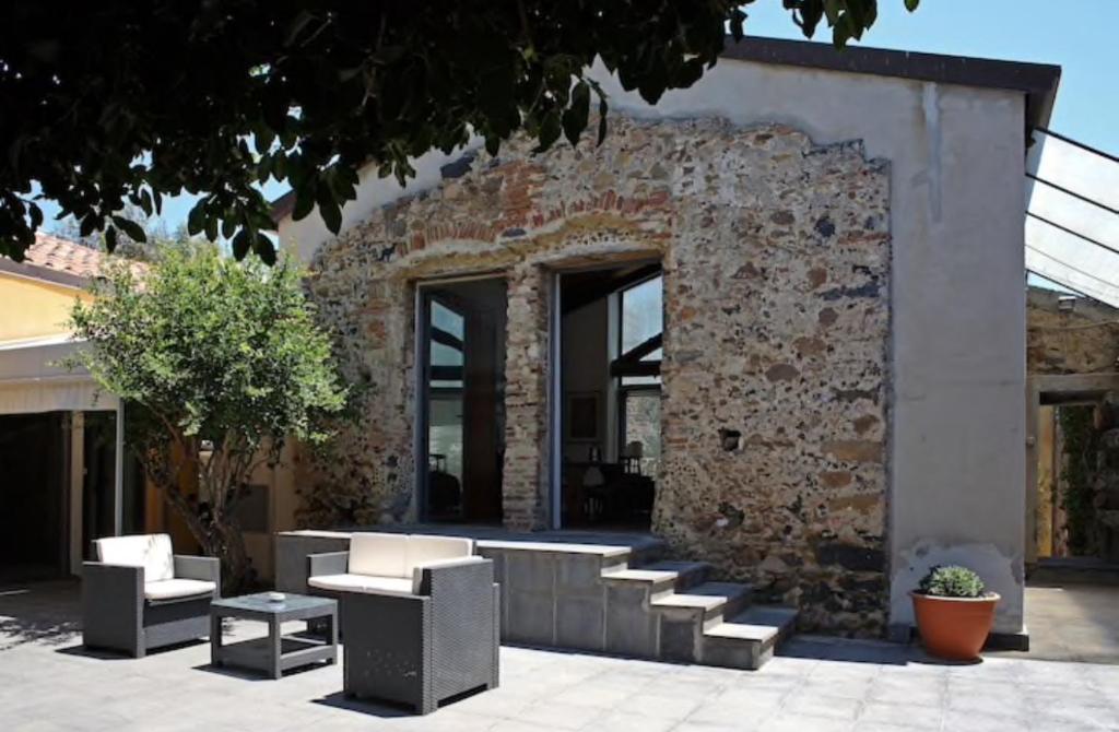 un bâtiment en briques avec un groupe de chaises et de tables dans l'établissement Anna e Gaetano, à Misterbianco
