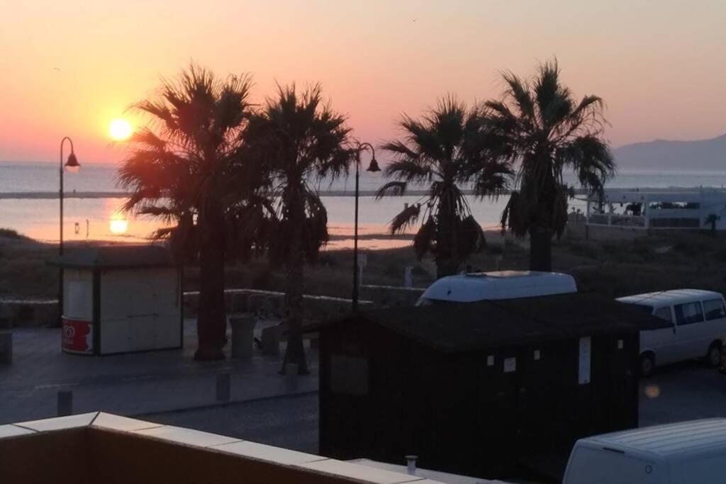 - un coucher de soleil sur un parking avec des palmiers dans l'établissement APARTAMENTO VISTA MAR LA TORTUGA, à Tarifa