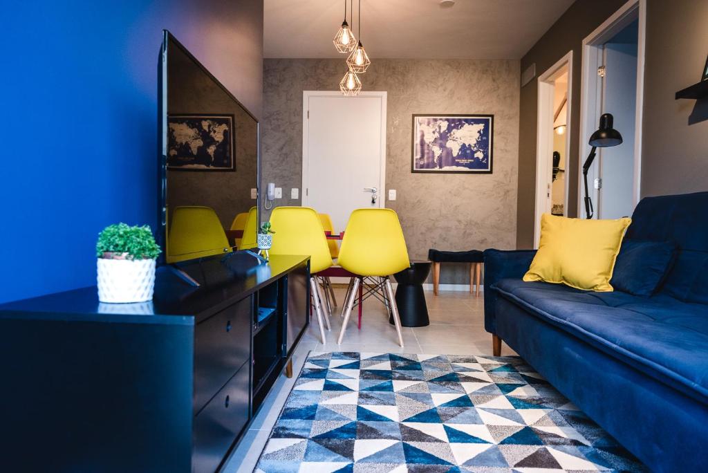 sala de estar con sofá azul y sillas amarillas en Happy Mood Lapa - Confort & Style in Rio's Bohemia en Río de Janeiro