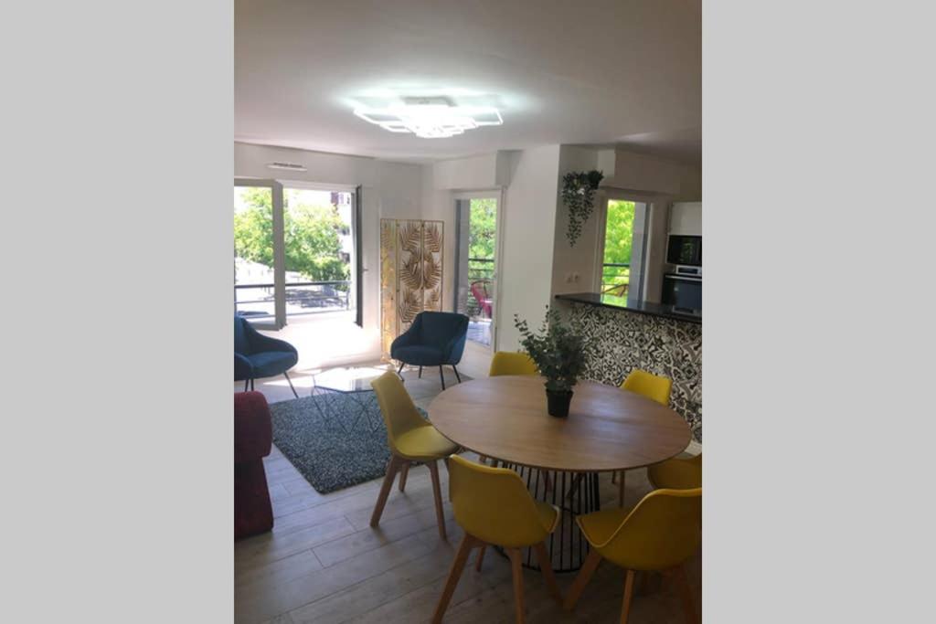 a dining room with a table and yellow chairs at Fruitiers1 in Saint-Denis