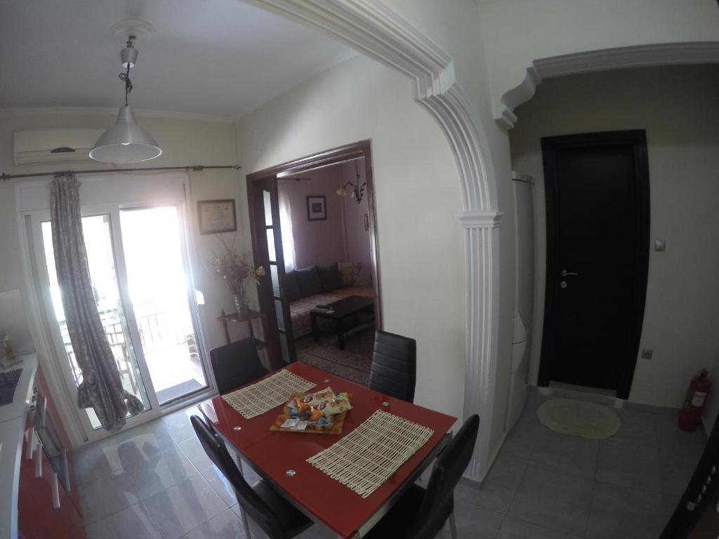 jadalnia z czerwonym stołem w pokoju w obiekcie Cozy and modern apartment w Korfu