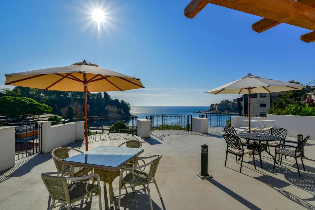 a patio with tables and chairs and umbrellas at Apartmani Djurovic in Ulcinj