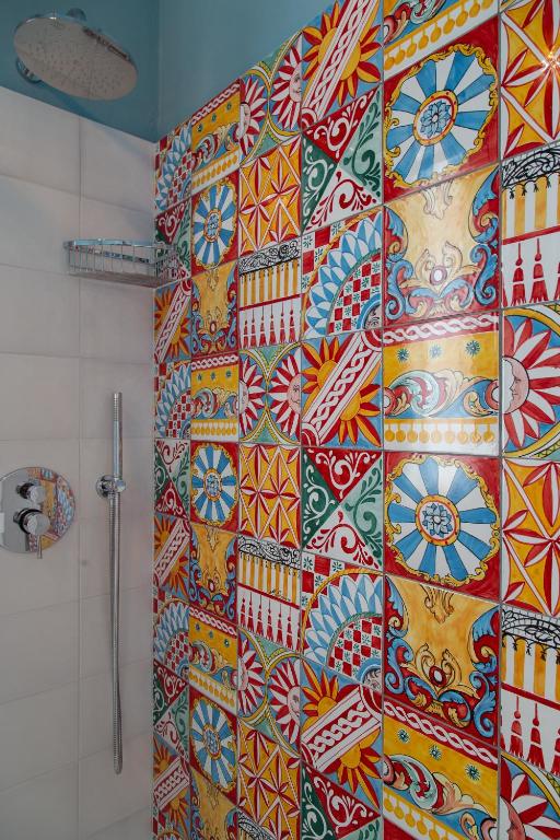 a shower stall with a colorful tile wall in a bathroom at il Palchetto B&B di Charme e Design in Palermo
