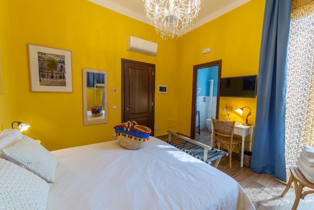 a bedroom with a white bed and a yellow wall at il Palchetto B&B di Charme e Design in Palermo