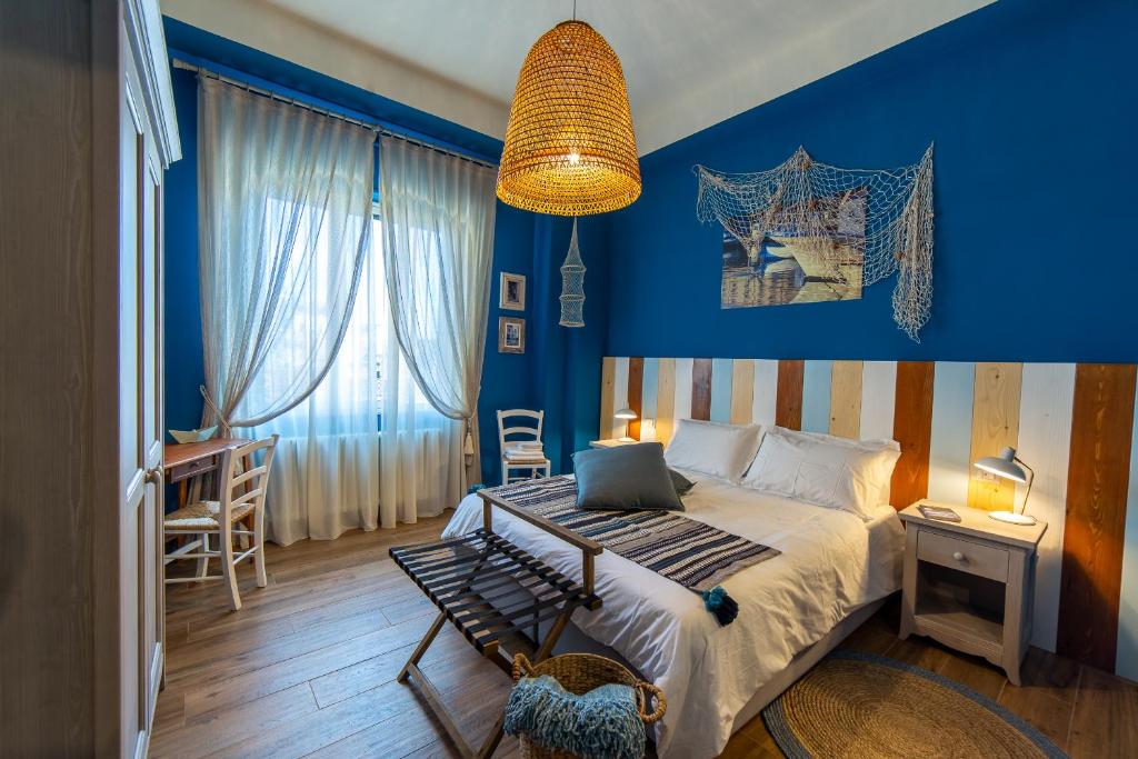 a bedroom with blue walls and a bed with a laptop on it at il Palchetto B&B di Charme e Design in Palermo