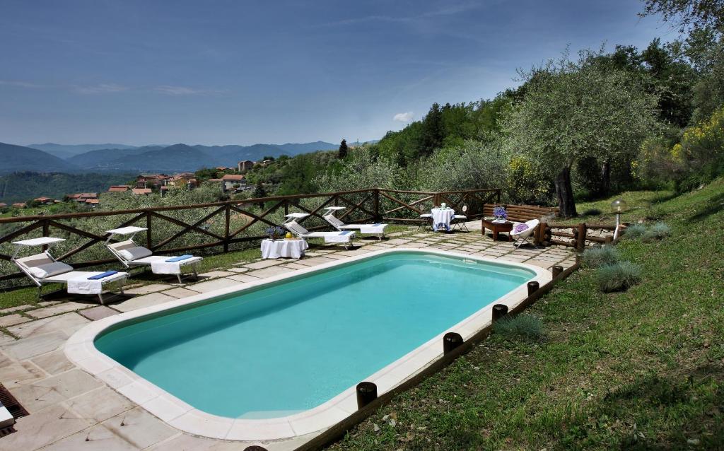 a swimming pool in a yard with chairs at VILLA BELLI - Luxury Villa with saltwater SWIMMINGPOOL in Agnino
