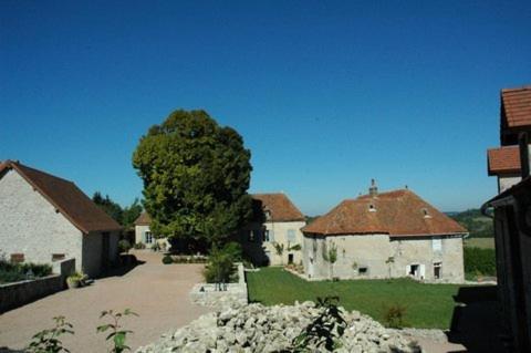 un grupo de edificios blancos con un árbol y una entrada en Le Manoir de Presle - Gîte, en Montaigu-le-Blin