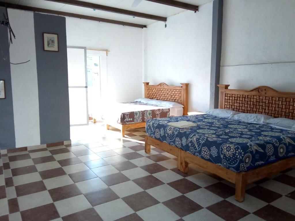 a bedroom with two beds and a checkered floor at Hotel Juarez in Cuernavaca