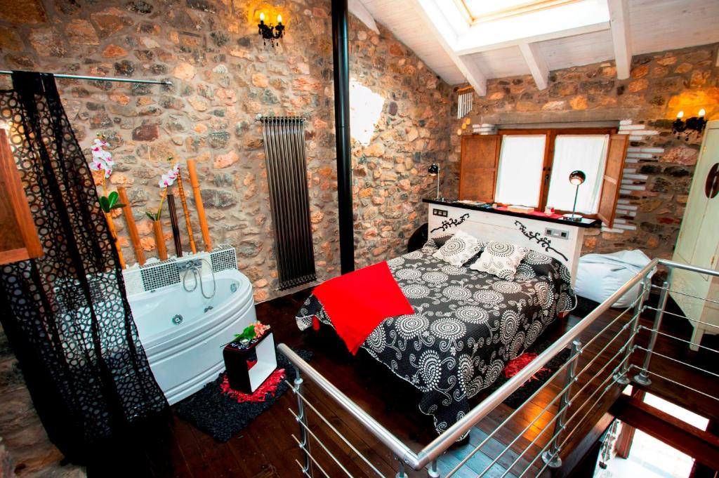a bedroom with a bed and a tub in a room at Casas Rurales Entre Babia y La Luna in Villafeliz