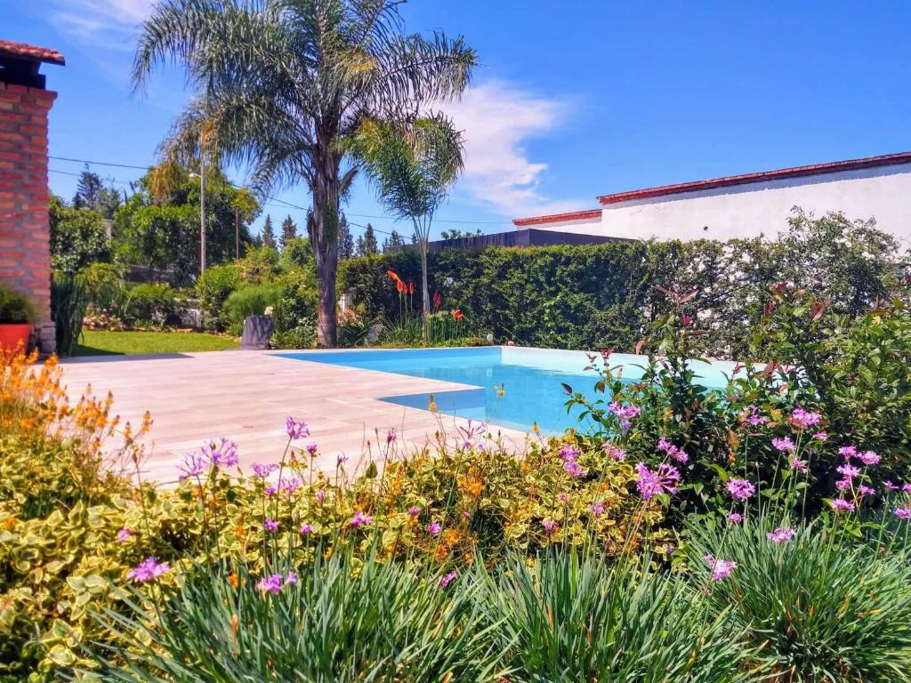 una piscina in un giardino fiorito di Casa de Campo Vaqueros Salta a Vaqueros