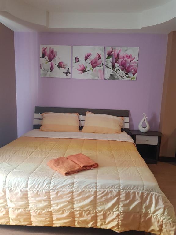 a bedroom with a bed with two paintings on the wall at Concordia Guesthouse in Jomtien Beach