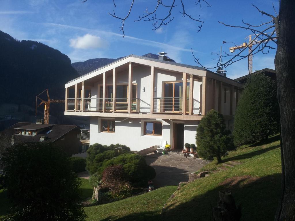 a house on a hill with people sitting in front of it at Residence Larciunei in Ortisei