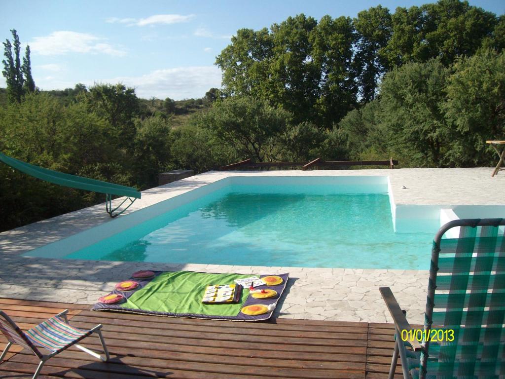 una piscina con mesa y sillas junto a ella en Casa Monte en Villa Icho Cruz