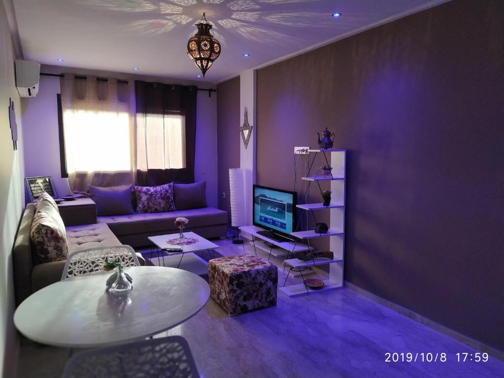 - un salon violet avec un canapé et une table dans l'établissement Opéra Appartement, Hivernage Marrakech., à Marrakech