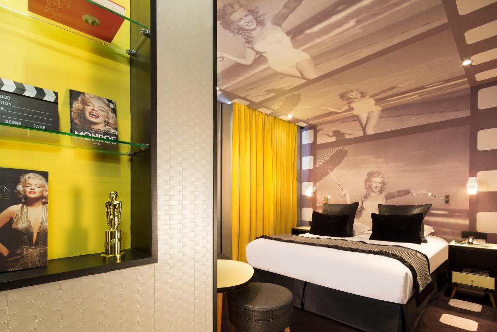 a hotel room with a bed, desk, and mirror at Platine Hotel in Paris