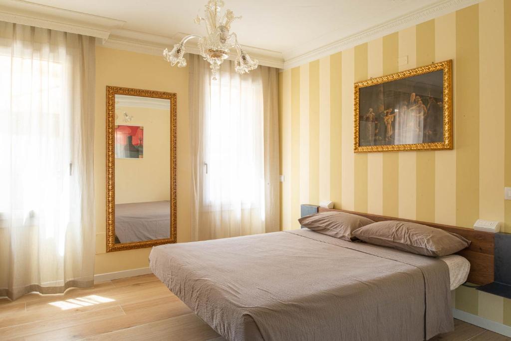 um quarto com uma cama e um espelho em Little House em Campo San Martino